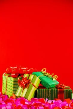 Wrapped boxes with presents against red background Stock Photos