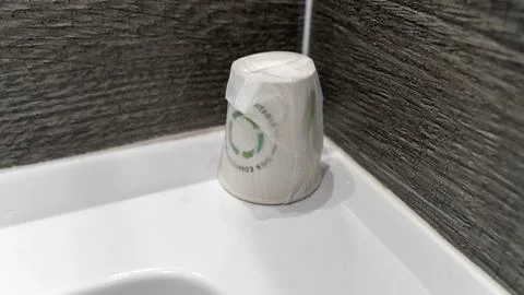 Wrapped ceramic drinking cup on a bathroom sink in a hotel Stock Photos
