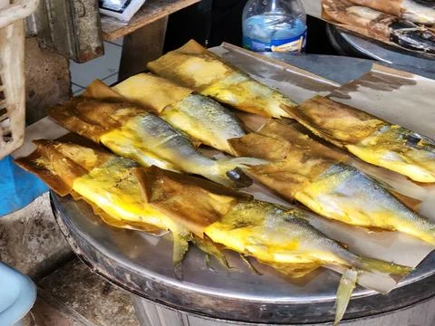 Wrapped cooked fish on round table for seafood stall branding visuals. Stock Photos