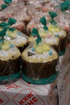 Wrapped Easter cakes with icing and sugar sprinkles in supermarket Stock Photos