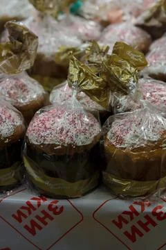 Wrapped Easter cakes with icing and sugar sprinkles in supermarket. Stock Photos