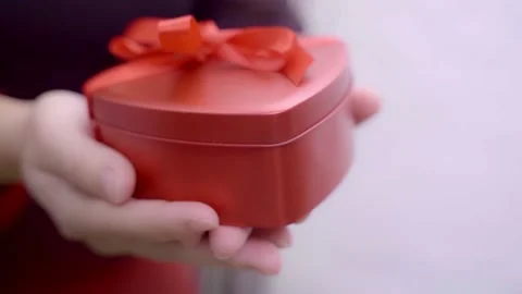 Wrapped gift box with red ribbon bow in female hand. Stock-Footage 232346684