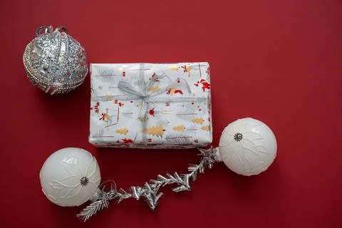 Wrapped gift box with silver bow, white balls gray baubles decoration Stock Photos