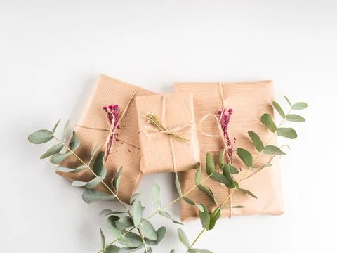 Wrapped gift boxes in craft paper with dried flowers decor Stock Photos