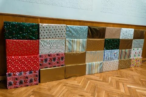 Wrapped Gift Boxes Line a Floor in a Room, Festive Holiday Pattern, Red, Gr.. Stock Photos
