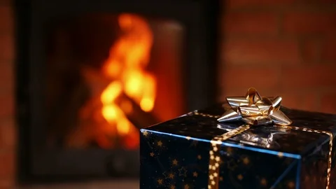 Wrapped gift spinning in front of fireplace - static camera 스톡 동영상 87911125
