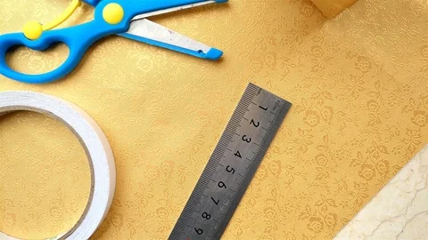 Wrapped golden present box with  wrapping tools nearby 4K Stock Footage 73000779