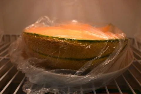 Wrapped melon half in a refrigerator Photos