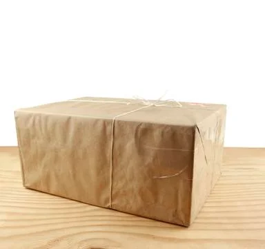 Wrapped package on table top in front of white Foto stock