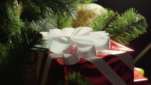 Wrapped present under decorated Christmas tree. Slow motion. HD Stock Footage 83323392