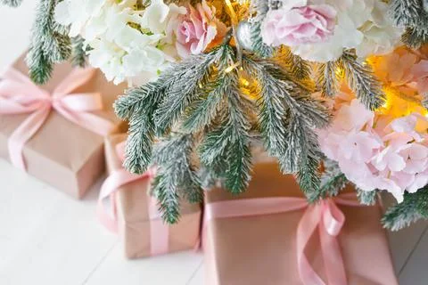 Wrapped presents, gift boxes with pink ribbons on white floor under festive.. Stock Photos