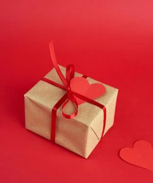 Wrapped square box with a gift in brown craft paper and tied with a thin silk Foto stock