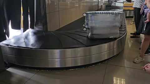 Wrapped suitcase is moving along the baggage carousel at an airport. Stock Footage 313020361