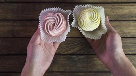 Wrapped sweets in hands on wooden background. Stock Photos