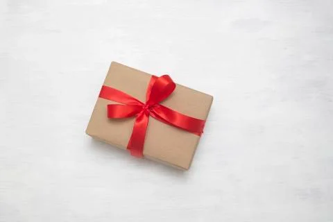 Wrapped vintage brown gift box with red ribbon bow, isolated on white Stock Photos