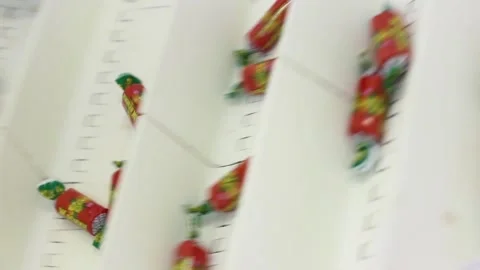 Wrapped in wrappers, sweets are moved along a conveyor belt Stock Footage 128643158