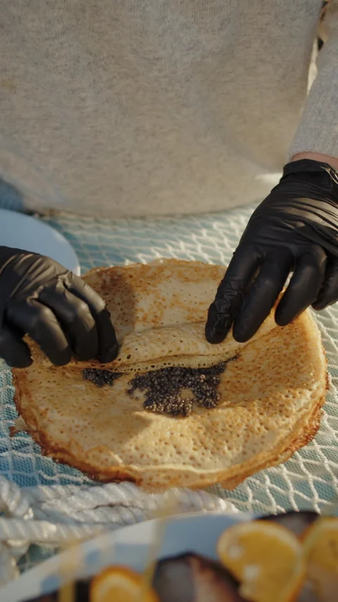 Wrapping black caviar in thin pancake Stock Footage 310006977