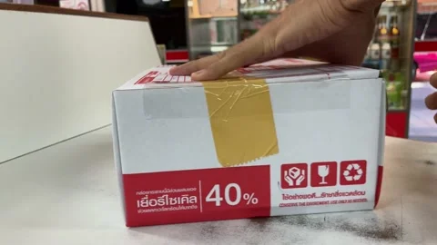 Wrapping the box at Thailand post office with sticky tape - Close up shot Stock Footage 172032147