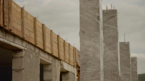 Wrapping concrete columns in foil to keep moisture during construction Stock Footage 324661166