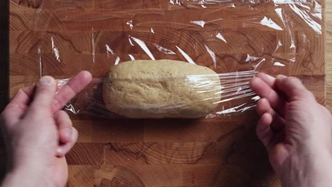 Wrapping Dough In Plastic Wrap By Hand Top View Stock Footage 333597553
