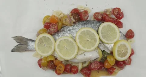 Wrapping a fresh sea bream into a baking paper Stock Footage 134630806