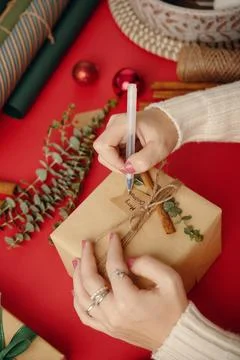 Wrapping Gift with Decorative Elements on Table Foto stock