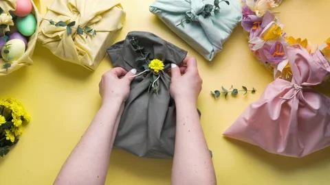 Wrapping a gift in eco friendly reusable fabric package Stock Footage 234824730