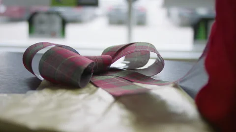 Wrapping a gift with a large festive bow. Stock Footage 130673061