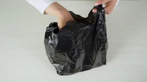 Wrapping Items in a Plastic Shopping Bag From Top View Vídeos de archivo 347626684
