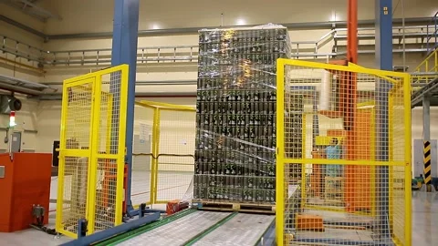 A wrapping machine wraps a batch of product with film. Stock Footage 231747734