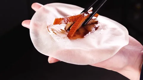 Wrapping Peking duck in thin pancake close up 4K Stock Footage 338338962
