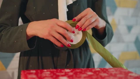 Wrapping presents with ribbons in cozy setting. Crafting seasonal presents Stock Footage 345168285