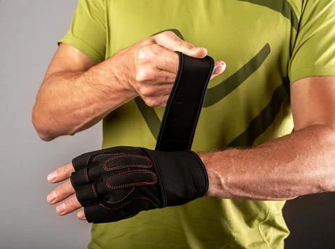 Wrapping, putting on training workout gloves on hands for wrist protection Stock Photos