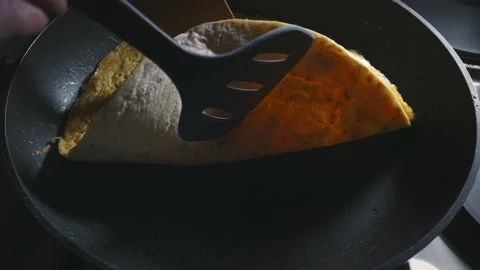 Wrapping tortilla with eggs in pan Video stock 166863451