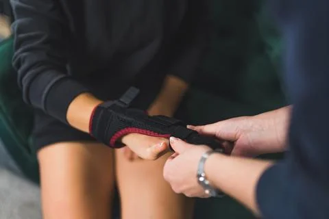 Wrapping a two-sided splint on the middle finger after an accident, indoors Stock Photos