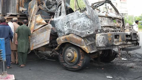 Wreckagge of Container  set on fire by protestants Kalma Chowk Lahore Stock Footage 240933062