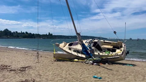 Wrecked sailboat aground on Kits Beach in Vancouver Stock Footage 338058458