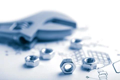 Wrench and nuts over technical drawing toned blue Stock Photos