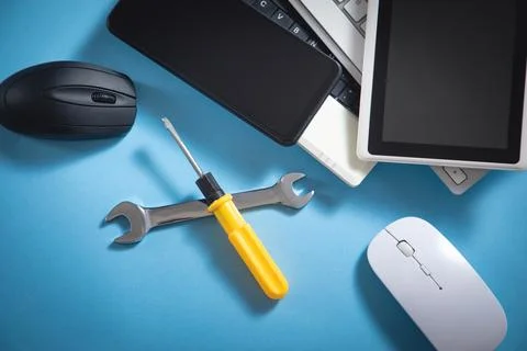 Wrench and screwdriver with a computer keyboard, smartphone, tablet, mouse... Stock Photos