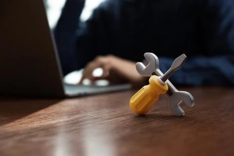 Wrench and screwdriver put on table in front of businessman or IT support Stock Photos