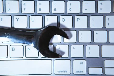 Wrench on a computer keyboard, close-up, selective focus Stock Photos