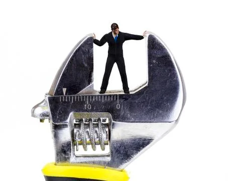 Wrench crushing a tiny man closeup Illustrazione stock