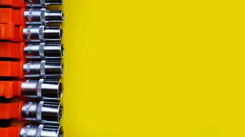 Wrench head bits for the screwdriver and other tools on bright yellow background Stock Photos