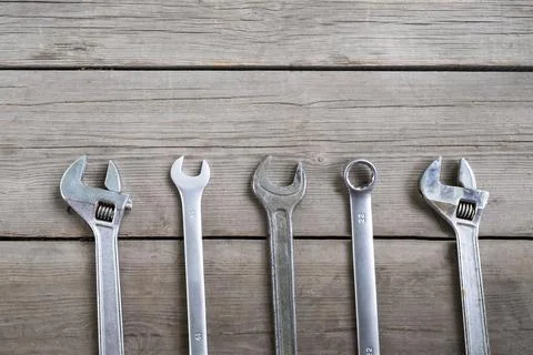 Wrenches and adjustable wrenches on an old wooden background. Top view 库存照片
