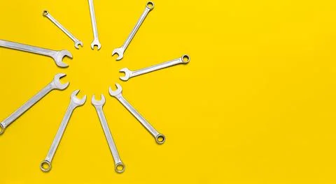 Wrenches different size in shape of sun on yellow background. Sunny banner wi Stock Photos