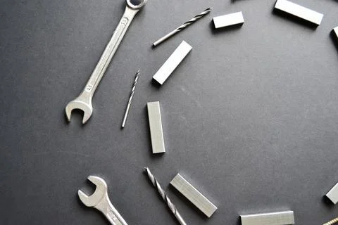 Wrenches, drills in a circle copy space on a black surface. Focus on foregrou Stock Photos