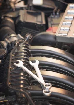 Wrenches lie on the engine of the car in the engine compartment. Stock Photos