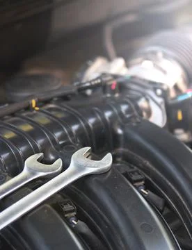 Wrenches lie on the engine of the car in the engine compartment. Stock Photos