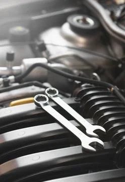 Wrenches lie on the engine of the car in the engine compartment. Stock Photos