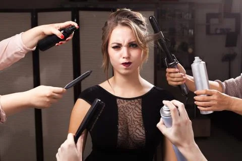 Wriggling model surrounded by hands with makeup products Stock Photos